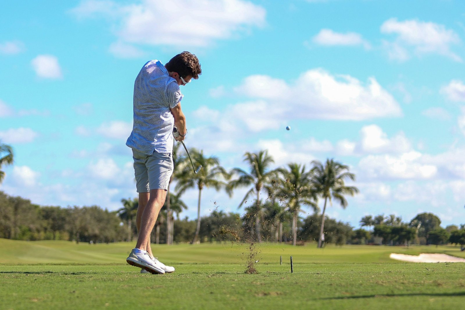 A man swinging a golf club on a golf course